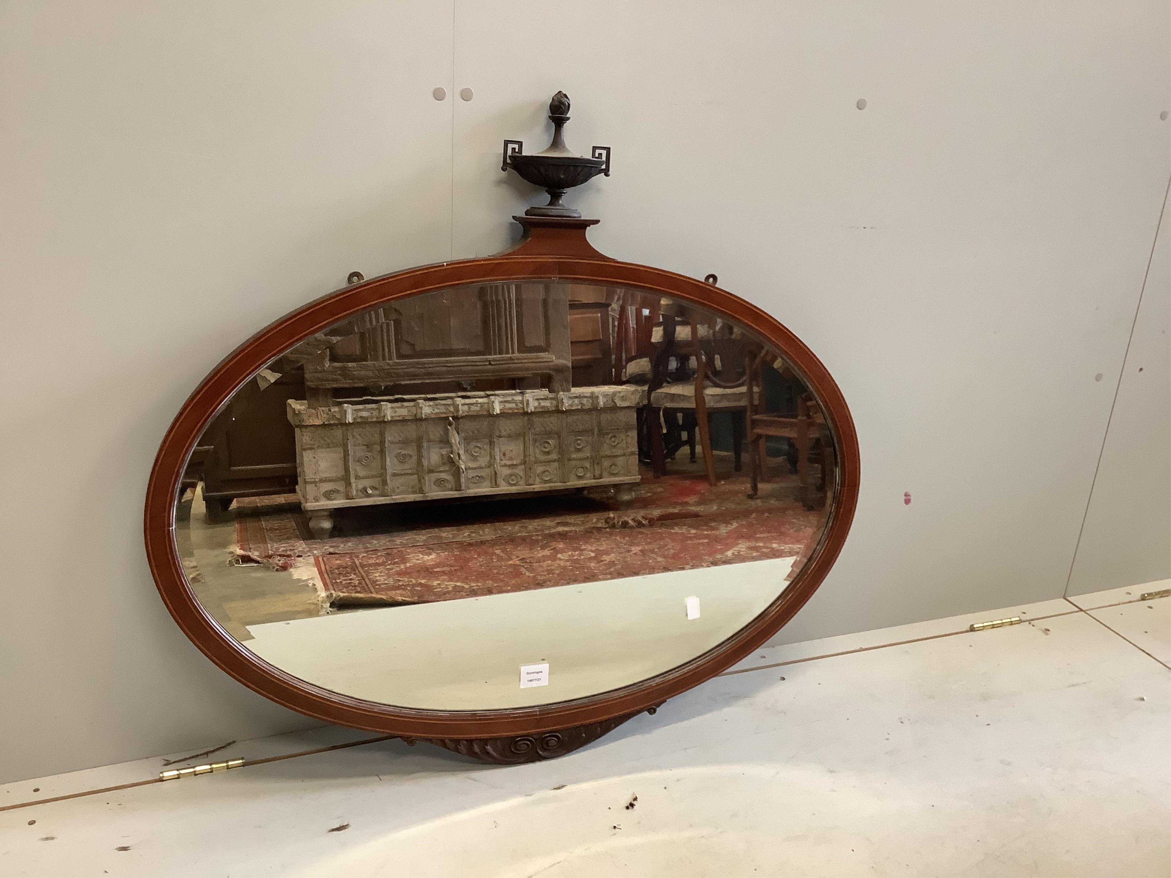 An Edwardian inlaid mahogany oval wall mirror, width 99cm, height 91cm. Condition - fair